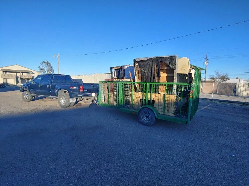 Shifty truck and green junk removal trailer loaded for haul-away